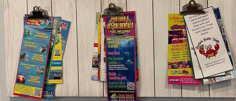 A wall with various colorful flyers and posters advertising different activities and services.
