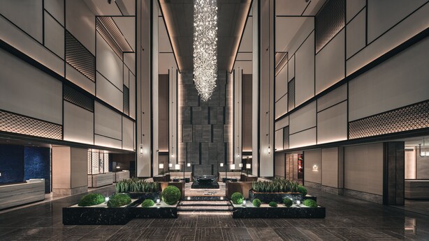 A spacious lobby with a central water feature, seating areas, and a modern chandelier. - HUALUXE Kunshan Huaqiao by IHG (Suzhou)