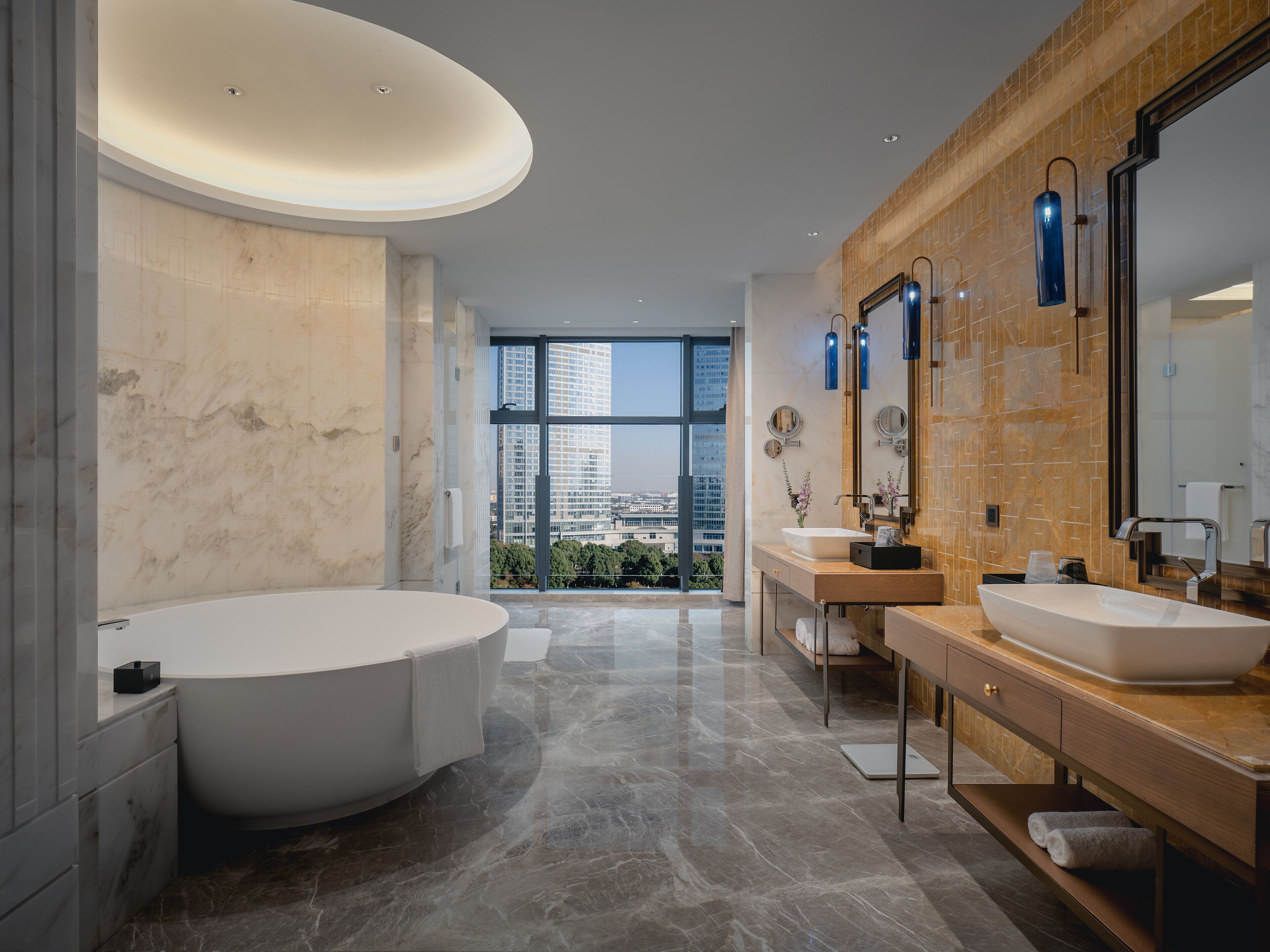 Un baño moderno con una bañera grande, dos lavamanos y un espejo amplio.