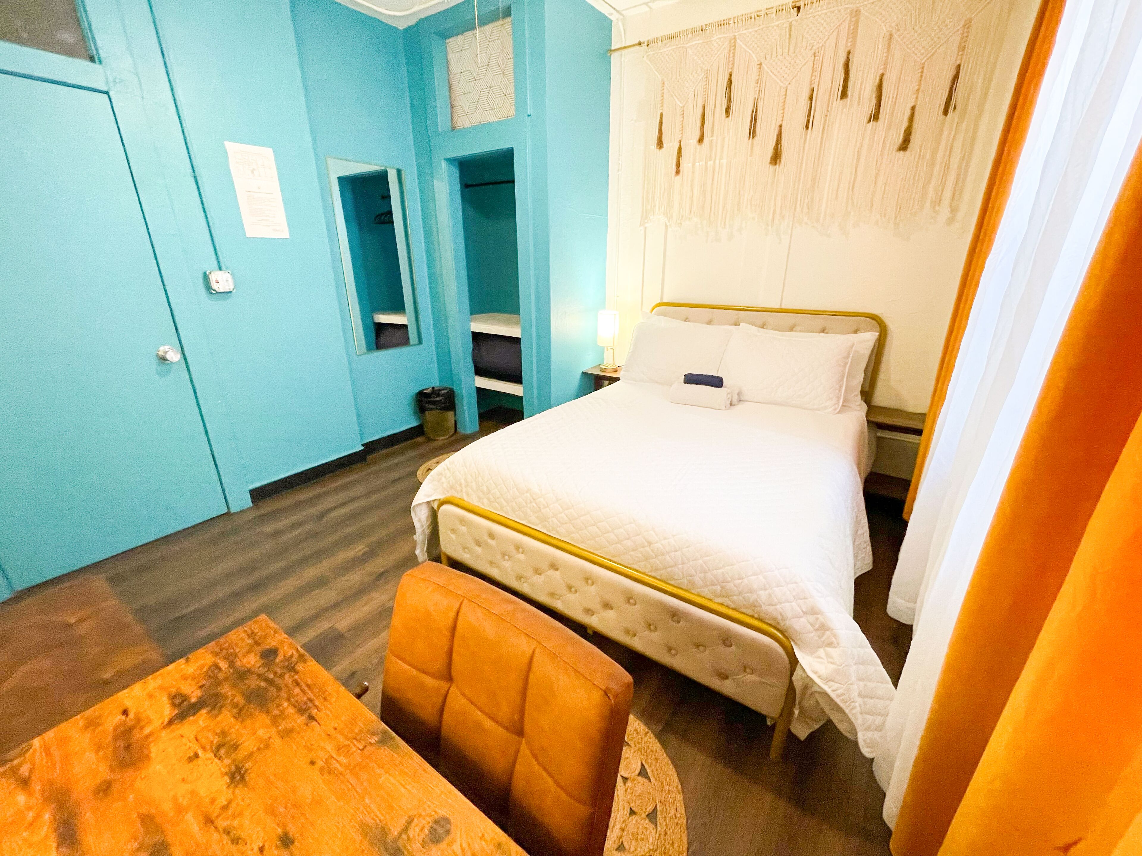 Une pièce comprenant un lit, une chaise, un bureau et une armoire.