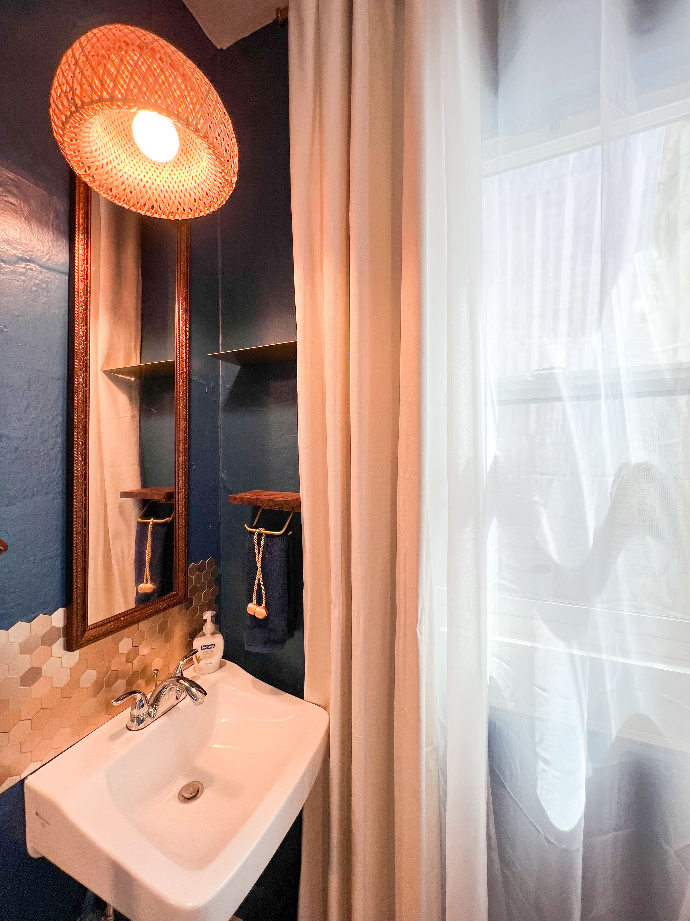 Un baño con un lavabo blanco, un espejo y una cortina de ducha.