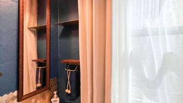 Un baño con un lavabo blanco, un espejo y una cortina de ducha.