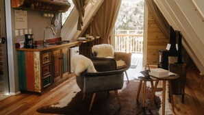 A cozy loft-style room with a kitchen area, a dining table, and a comfortable seating area. - Estância Nazari (Urubici)
