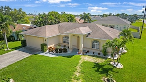 A single-story house with a tiled roof, a front porch, and a well-maintained lawn.