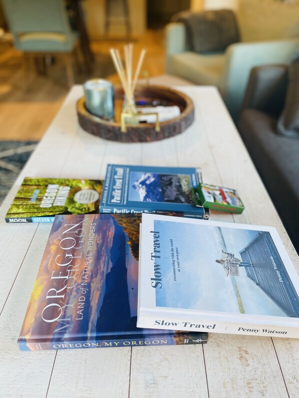 Ein Holztisch mit mehreren Büchern, darunter 'Oregon My Oregon' und 'Slow Travel' von Penny Watson.