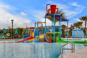 Ein Wasserpark mit einer zentralen Spielanlage, Rutschen und einem Schwimmbecken.