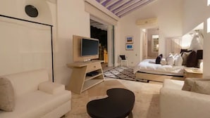 Una sala moderna con televisor, sofá y una original mesa negra.
