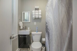 Une petite salle de bain comprenant des toilettes, un lavabo et un porte-serviettes.