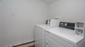 Une buanderie équipée d’un lave-linge, d’un sèche-linge et d’un panneau de commande.