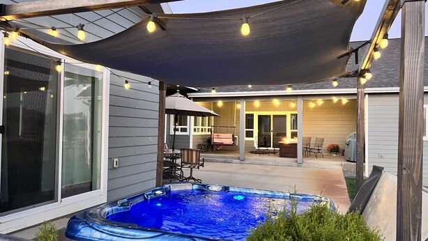 A backyard with a hot tub, patio furniture, and string lights. - Country Living and Views; Full RV hookup available (Moscow)