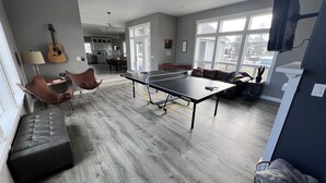 A spacious living area with a ping pong table, leather chairs, a sofa, and a guitar. - Country Living and Views; Full RV hookup available (Moscow)