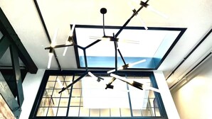 Un moderno soffitto con finestra a lucernario e lampadari a sospensione.