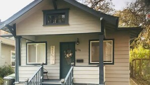 A two-story house with a front porch, a welcome sign, and a number 144 on the door.