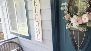 A blue door with a 'WELCOME' sign and a floral wreath.