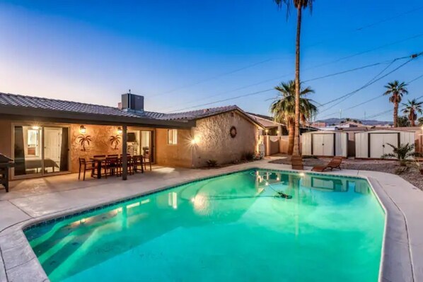 A residential property with a swimming pool, a patio with outdoor furniture, and a stone wall. - “THE SANDY WAKE”Desert Oasis Sleeps 8 with a pool (Lake Havasu City)
