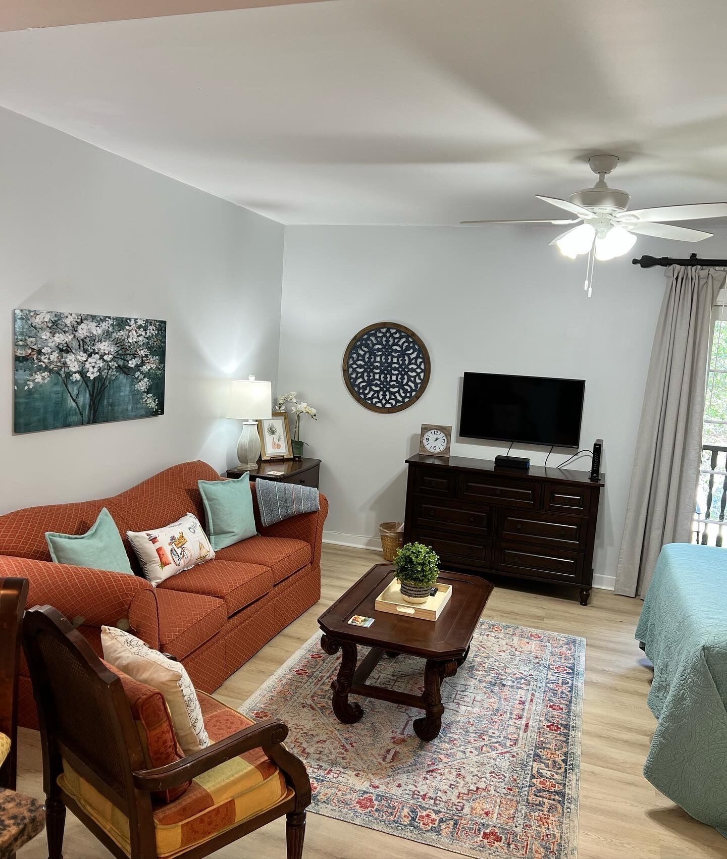 A living room with a sofa, coffee table, TV, and decorative items.