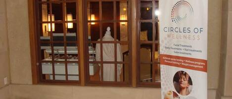 A salon with a large window and a signboard for 'Circles of Wellness' offering various treatments.