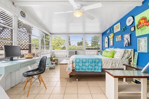 A bedroom with a bed, a desk with a computer, a chair, and a ceiling fan. - Vibrant Tropical Escape – Just Minutes from the Beach + Serene, Fenced Yard! (Largo)