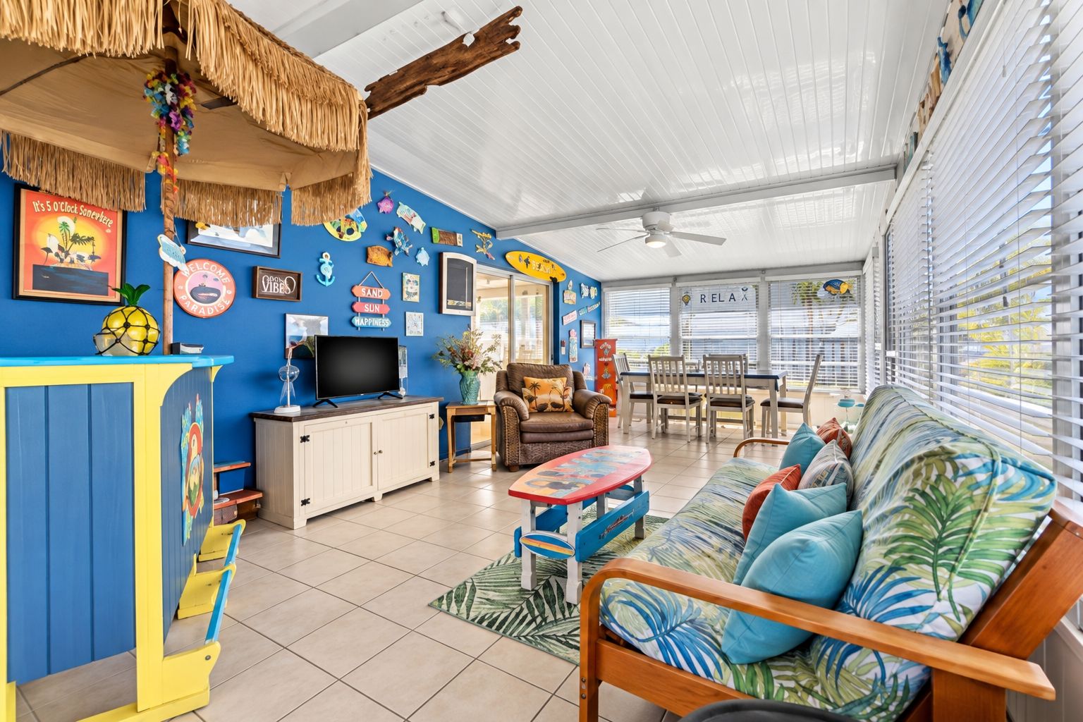 Ein Zimmer mit Fernseher, Sitzecke und einer Wand mit verschiedenen Schildern und Bildern.