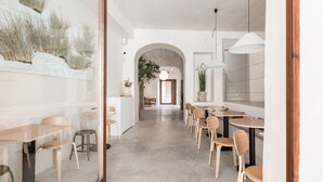 A modern interior with a long corridor leading to a dining area with wooden tables and chairs. - Meem Townhouse (Sóller)