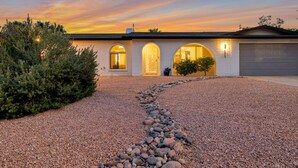 A modern house with a gravel driveway leading to a garage. - Preserve Oasis-Pool · Casita · Game Room · Treehouse (Phoenix)