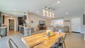 A modern kitchen with stainless steel appliances, a wooden dining table, and pendant lighting. - Preserve Oasis-Pool · Casita · Game Room · Treehouse (Phoenix)