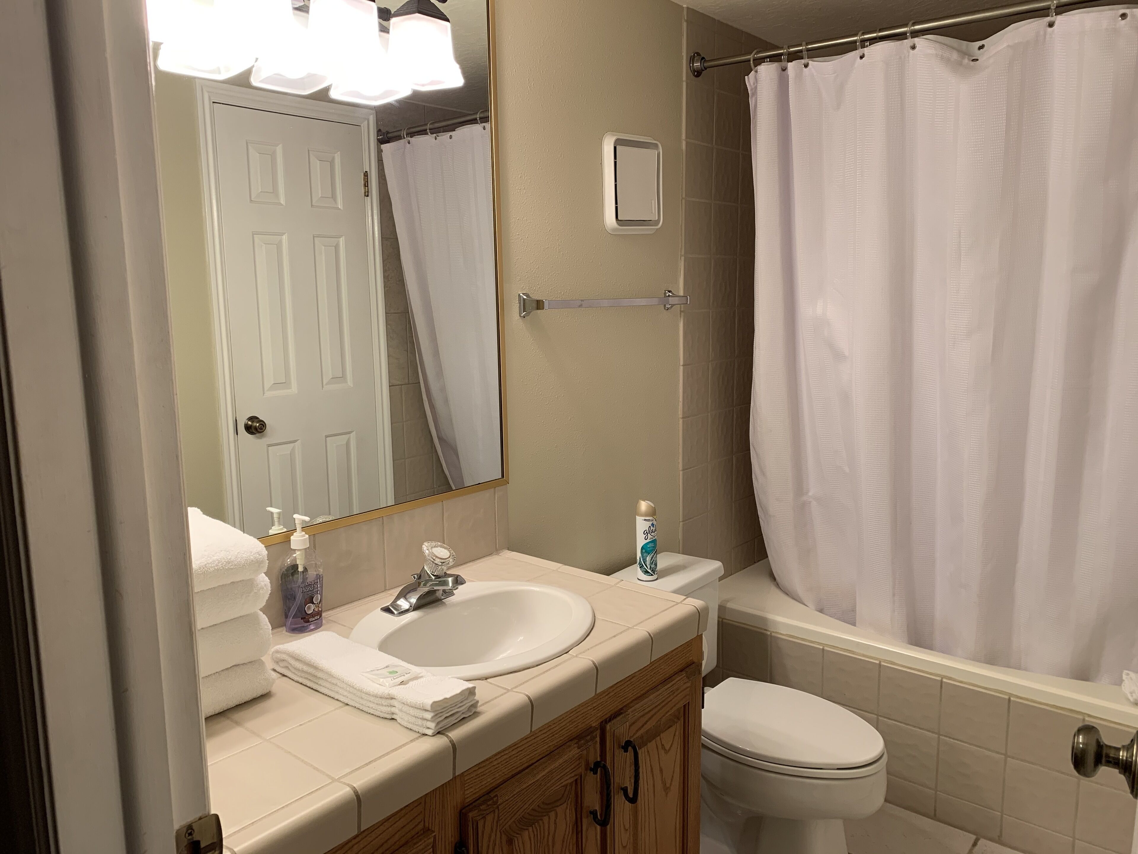 Baño con lavabo, inodoro y cortina de ducha.