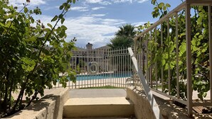 A pool area with steps leading up to a gated entrance, surrounded by greenery. - Darling 2 Bed 2 Bath Condo in Sports Village - Updated! (St. George)