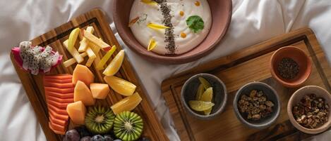 Una tabla de madera con frutas cortadas y un tazón de yogur con semillas.