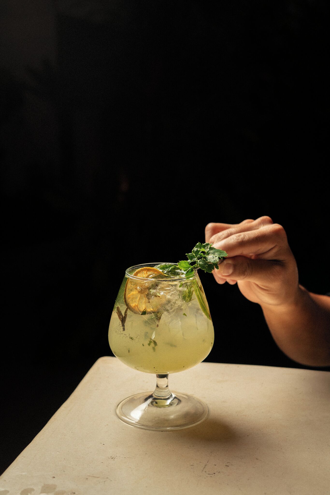 Een cocktailglas met garnering op een tafel.