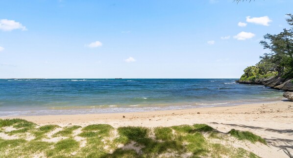 Relax on the wide sandy shores and enjoy the gentle waves in this serene beach setting.