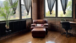 Una habitación con sofá de cuero, escritorio de madera y un radiador.