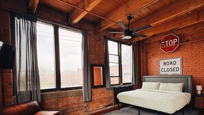 Una habitación con una cama, un sofá, un ventilador de techo y un cartel de 'Road Closed'.