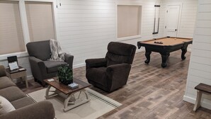 A living room with a pool table, two armchairs, a sofa, and a coffee table. - The Corner Cottage with Private Fishing Pond (Roland)