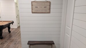 A corner room with a wooden bench, a pool table, and a welcome sign on the wall. - The Corner Cottage with Private Fishing Pond (Roland)