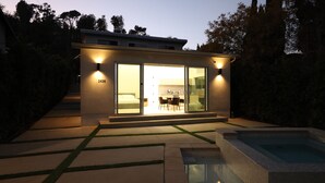 Ein modernes Haus mit Glastür, Schwimmbad und gepflegtem Garten.