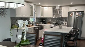 A modern kitchen with white cabinets, stainless steel appliances, and a central island.