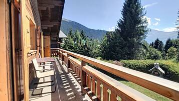Ein hölzerner Balkon mit Blick auf eine Berglandschaft.