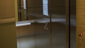 En hissinredning med dörrar i rostfritt stål, en skylt som påminner om att man ska respektera viktgränsen och en indikator som visar vilken våning hissen befinner sig på.