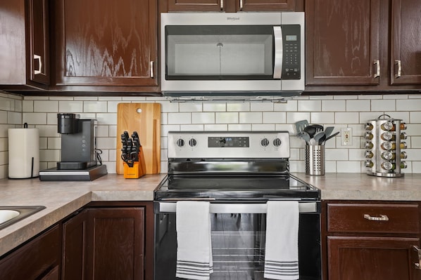 Enjoy cooking in this fully equipped kitchen with a microwave, stove, coffee maker, and ample storage.
