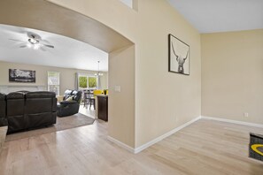 Relax in this stylish living area with a high ceiling, ceiling fan, and comfortable sofa.