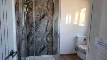 Modern bathroom with a walk-in shower and practical amenities.