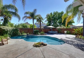 A backyard with a swimming pool, a wooden deck, and a patio area. - Luxurious spa-like oasis with pool, 4bdr/ 3br (Elk Grove)