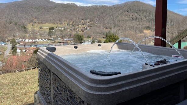A hot tub with a view of a town and mountains in the background. - Amazing Long Range Views in central Maggie Valley. (Maggie Valley)