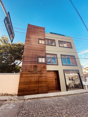 Een modern gebouw met een houten gevel, meerdere ramen en een duidelijke ingang.