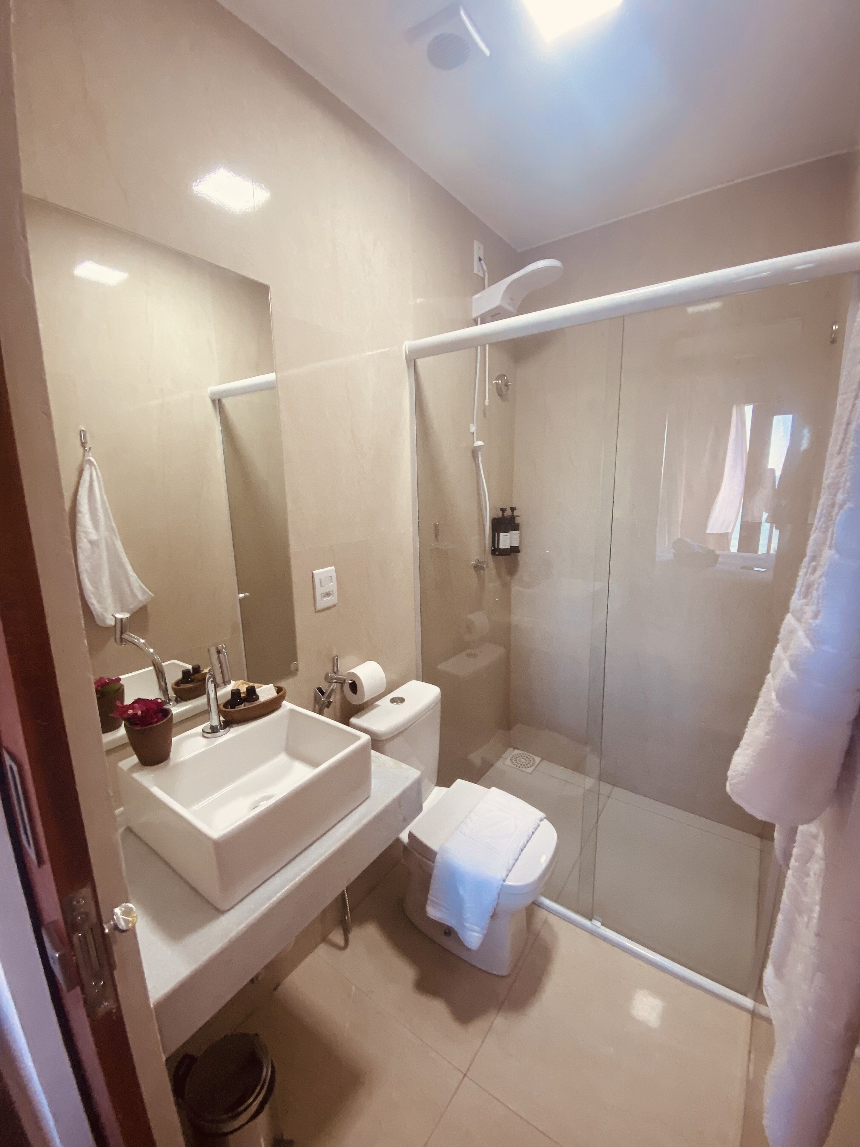 A modern bathroom with a glass-enclosed shower, a double sink vanity, and a toilet.
