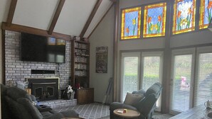 Un salon chaleureux avec une cheminée, une bibliothèque, un canapé confortable et une table à manger.