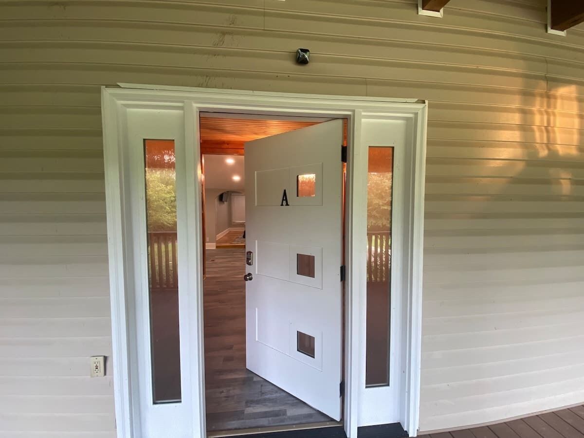 A white door with a number 'A' on it, leading to a wooden staircase.