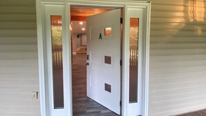 Una puerta blanca con el número 'A', que da a una escalera de madera.