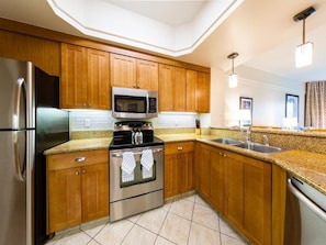 Enjoy cooking in this well-equipped kitchen with appliances, granite countertop, and stainless steel sink.